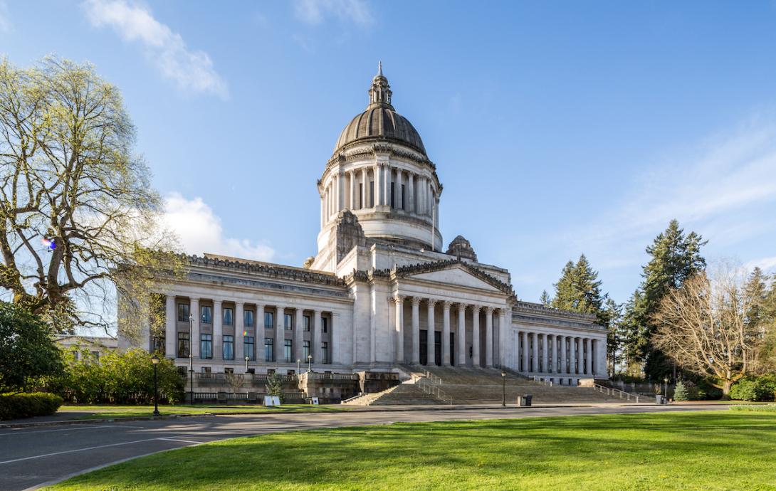 A large white building with a tall tower and staircase